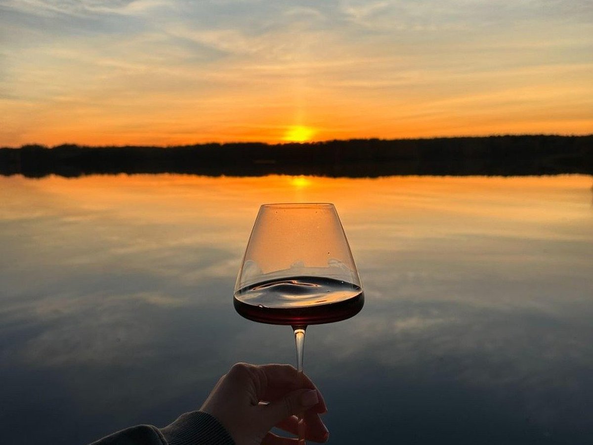 Sunset Views — wine glass at golden hour over the lake